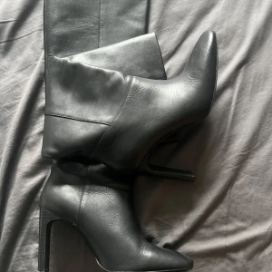 Svarta stövletter med klack - GARDEROBSRENSNING! Aldrig använda, köpta för 1700kr. 8-10cm klack, inte helt säker! Knähöjd