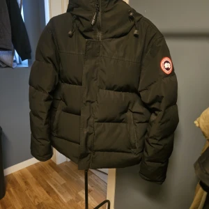 Svart pufferjacka från Canada Goose XL - Canada Goose macmillan parka i storlek XL/TG fusion. Normal i storlek. Passar mellan 170-185cm. Köpt hos kaufmann vintern 2023. Använd väldigt lite och är i fint skick.