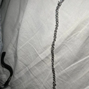 Kedjearmband i silverfärg - Stilrent armband med grova kedjelänkar i silverfärg. Klassisk design med karbinhake som lås, perfekt för att ge en edgy touch till din outfit. Passar både tjejer och killar som gillar minimalistiska accessoarer.