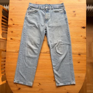 Weekday Galaxy Loose Straight Jeans - Säljer ett par ljusblåa Weekday Galaxy Loose Straight jeans i klassisk femficksmodell. Jeansen har rak passform med loose fit och är tillverkade i 100% bomull. Perfekta för dig som gillar en avslappnad och stilren look.