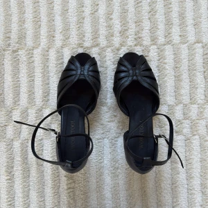 Svarta dansskor - Svarta dansskor, perfekta för att dansa high heels! De är från Worktool och är endast använda i en termin. Skorna har öppen tå, smala remmar över foten och runt vristen med spänne. Tillverkade i skinnliknande material och har en elegant, tidlös look som passar till många outfits. Storlek 36, men obs att dansskor är större i storleken, dessa passar mig som i vanliga fall har storlek 37/38🩷 PRIS PÅ HEMSIDAN: 1,400kr