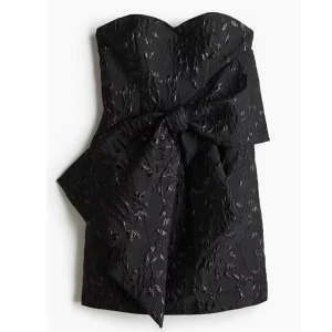 Svart axelbandslös kort klänning med rosett - Snygg svart axelbandslös klänning med stor rosett som är slutsåld ifrån H&M. Klänning är i storlek S och är använd en gång. Har tyvärr inga bilder med klänningen på då den är för liten🌸 