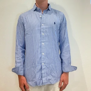 Blåvit Randig Ralph Lauren Skjorta  - Vit/ blå randig Ralph lauren skjorta || Storlek S (Custom Fit) || Skjortan är i bra skick || Mitt pris 649kr || Modellen på bilden är 170cm och väger 62kg || Tveka inte på att höra av dig vid frågor eller funderingar 