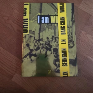 I am WHO - Cool bok med urban känsla och starka färger, perfekt för dig som gillar musik och popkultur. Omslaget pryds av gruppnamn och medlemmar, vilket gör den till ett måste för fans och samlare.