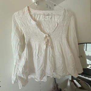Odd molly blus  - Luftig vit blus från H&M med smock upptill och v-ringning med söt knytning framtill. Långa ärmar med lätt volang och avslappnad passform. Perfekt för en bohemisk vibe och passar till både jeans och kjol. Den har lite mindre fläckar men inget som märks när man har på sig den💗💗