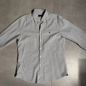 Morris skjorta  - Snygg skjorta från Morris i vitt och mörkblått randigt mönster. Klassisk button-down krage. Storlek M, ny skick! Pris 459