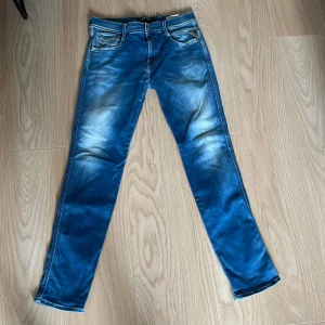 Anbass hyperflex från Replay w 29 L 32 - Snygga blå jeans från Replay med en modern slim passform. De har en dragkedja och knapp framtill samt klassiska fem fickor. Perfekta för en stilren look. W 29, L 32