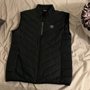Mörk blå dunväst från EA7 -  mörk blå ea7 väst, använd typ 2-3 gånger. Matchar med mycket, sköna fickor, sitter skönt. Storlek på västen är M men kan funka på S, själv har jag S och den satt bra. Köpt för 2500kr. Pris kan diskuteras