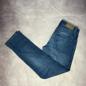 Selected Homme jeans - Waist 30, 32 längd. Snygga blå jeansbyxor från Tommy Hilfiger med klassisk femficksdesign. As sköna, italiensk fabrikat, stretchiga. Skick 10/10, nyskick. Nypris ligger på 1200kr.