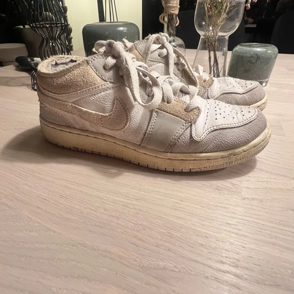 Säljer ett par Nike Jordan sneakers i beige och vit med snörning. Skorna har en klassisk design med Nike-loggan på sidan. Perfekta för en avslappnad stil. Köpta i New york på JD sports ( äkta ) köptes för ca 2000 svenska kronor.. Kengät.