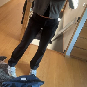 Svarta byxor - Snygga svarta byxor med en klassisk look. De har en rak passform och är perfekta för en stilren outfit. Byxorna är lågmidjade och passar bra till både vardag och mer uppklädda tillfällen.