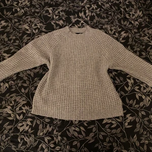 Beige stickad tröja från 157 - Säljer en mysig beige stickad tröja från 157. Tröjan har en klassisk design med rund hals och långa ärmar. Perfekt för kyligare dagar och ger en stilren look. 