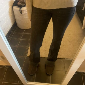Svarta jeansbyxor - Snygga svarta jeansbyxor med en tight passform. De har en klassisk design med fem fickor och knappdetaljer. Perfekta för en stilren look.
