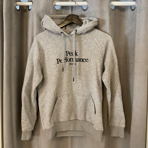 Grå hoodie från Peak Performance - Säljer en stilren grå hoodie från Peak Performance med logga på bröstet. Tröjan har inte använd mycket och är i fint skick. Storlek S