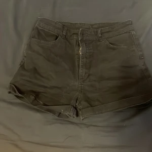 Svarta shorts från H&M - Snygga svarta shorts från H&M med klassisk design. De har en dragkedja framtill och är perfekta för en avslappnad stil. Shortsen har fickor både fram och bak, vilket ger en praktisk touch.