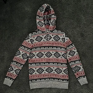 Stickad hoodie med mönster  - Lite tjockare stickaf hoodie med mönster i extremt mjukt och varmt material vilket gör den perfekt nu till våren. Storlek M med väldigt bra passform 