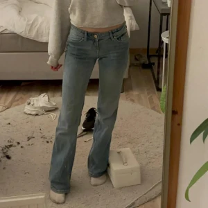 Blå bootcut jeans - Snygga blå bootcut jeans med klassisk femficksdesign och knappgylf. Perfekta för en avslappnad stil. Passar bra till sneakers eller boots. Jag är 1,69 cm lång och de sitter bra på mig. Köpta från bershka för 600kr