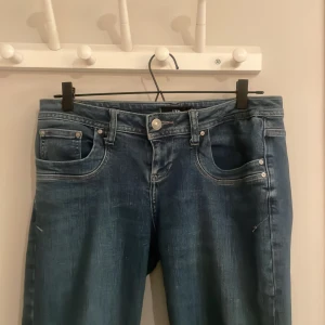 Blå jeans från LTB - Snygga blå jeans från LTB med klassisk femficksdesign och knappgylf. Jeansen lågmidjade med bootcut. Storlek W28 L 32 men är lite stora i storleken. Byxorna är lite sliten längst ner vid byxbenet (Visar på bilderna)  men annars är dem i superbra skick😊