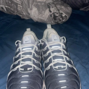 Nike Vapormax sneakers - Snygga Nike Vapormax sneakers i en stilren grå och svart färgkombination. Skorna har en unik sula med synliga luftkuddar för extra komfort och stil. De har snörning och en modern design som passar perfekt för en sportig look. Pris kan diskuteras!!