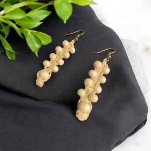 Beige örhängen med pärlor - Eleganta beige örhängen med flera runda pärlor i rad. De har en krok för enkel användning och ger en stilren look. Perfekta för att lägga till en touch av elegans till din outfit.