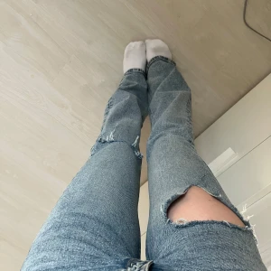 Blåa lågmidjade bootcut jeans med hål - Snygga blå lågmidjade bootcut jeans med hål. Storlek XS. Finns en liten fläck (sista bilden)