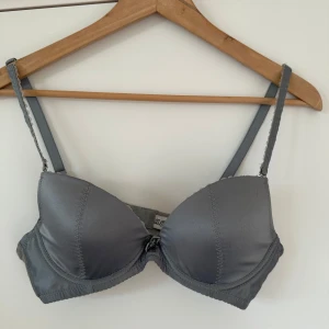 Grå balconette behå (aldrig använd) - Grå behå i balconette-modell med fina spetsdetaljer och avtagbara axelband. Provat den gång och tvättad en gång, aldrig använd. Från M G H Y. Storlek 75B.   Hämtas i Stockholm eller skickas mot porto.  Kolla gärna mina andra annonser också! Samfraktar gärna! 🥳