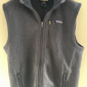 Blå fleeceväst från Patagonia - Säljer en stilren grå fleeceväst från Patagonia använd ett få tal gånger. Västen har en dragkedja framtill och praktiska fickor med dragkedjor. Perfekt för lager-på-lager. Kan gå ner vid pris vid snabb affär 