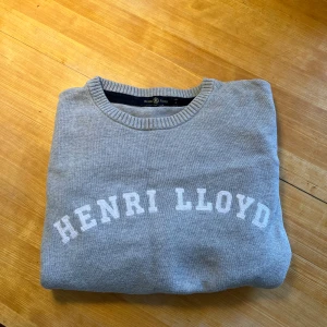 Grå Henri Lloyd tröja - Hejsan! Säljer min snygga Henri Lloyd tröja som är ljus grå. Tröjan är storlek L men sitter som M och skulle också passa någon som bär storlek S. Tröjan är använd varsamt och har inga hål, fläckar eller liknande. Tröjan passar perfekt nu till sommarn. Om man har frågor är det bara att skriva, samt är priset diskuterbart!
