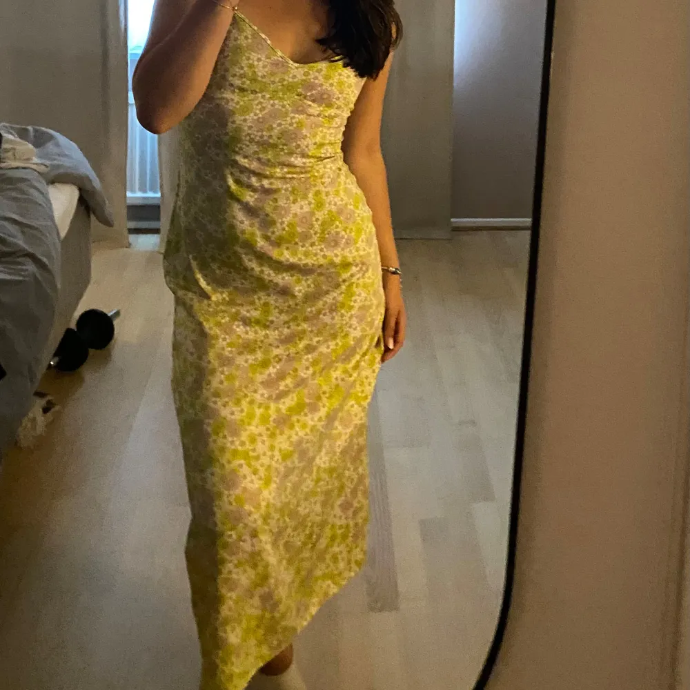 Säljer en blommig långklänning från Zara i grönt, vitt och lila. Klänningen har smala axelband, v-ringning och öppen rygg. Materialet känns lätt och svalt🌼. Mekot.