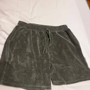 Grå frottéshorts med snörning från AVENY - Mysiga grå shorts i frotté från AVENY med elastisk midja och snörning. Shortsen har sidofickor fram och bakfickor, perfekta för en avslappnad stil. Materialet är 80% ekologisk bomull och 20% elastan. Nypris på dessa är 900kr. 