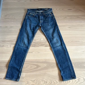 Blå jeans från Replay - Säljer ett par snygga blå jeans från Replay, modell Grover. De har en klassisk femficksdesign och en straight passform. Perfekta för en avslappnad stil.