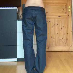 Mörkblå  jeans med slitningar - Mörkblå jeans med slitningar/hål. Obs! Vet inte ifall hålen är del av designen eller om det är slitningar. Hör av dig vid fler frågor!💕
