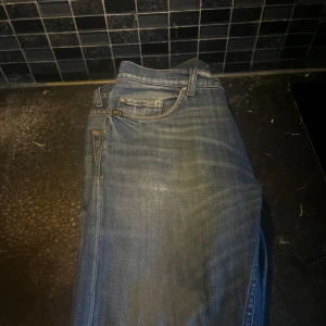 Blå tiger of sweden jeansbyxor - Säljer ett par klassiska blå jeansbyxor i stilren design. Byxorna har en normal passform med fem fickor och bälteshällor. Perfekta för en avslappnad stil. Från tiger of sweden. Tvär feta 