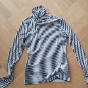 Randig polotröja från H&M - Säljer en svartvit randig polotröja från H&M i storlek XS. Tröjan har långa ärmar och en klassisk polokrage. 