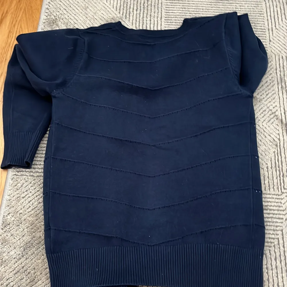 Snygg mörkblå kofta med knappar framtill och diskreta ränder. Perfekt för en stilren look. Koftan har långa ärmar och ribbade kanter för extra komfort. ❗️några diamanterna har ramlat av, men den märks inte så mycket❗️. Neuleet.
