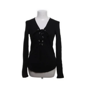Svart långärmad topp från GinaTricot - Snygg svart långärmad topp från GinaTricot med v-ringning och cool snörningsdetalj framtill. Bra skick och inte så använd, lite nopprig under armarna 