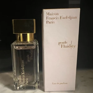 Gentle Fluidity Gold Edp från Maison Francis Kurkdjian - Säljer en flaska Maison Francis Kurkdjian Gentle Fluidity Gold. En doft för både kvinnor och män. Doften har noter av vanilj, puder, mysk och sötma. Toppnoterna är enbär och muskotnöt. Hjärtnoten är koriander. Basnoterna är vanilj, mysk, amberwood och karamell. Flaskan innehåller 35 ml Eau de Parfum och är knappt använd. Givetvis förvarad mörkt och svalt. Kvittot kan ses på andra bilden.