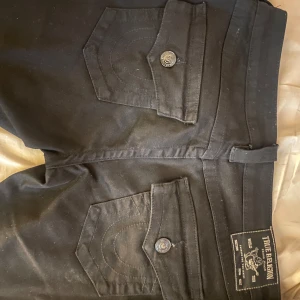 True religion joey bootcut svarta  - Jättebra skick, inga defekter, men säljer pågrund av att storleken är för stor för mig tyvärr. Köptes för 1400kr och är i storlek 27. Skriv gärna innan köp!