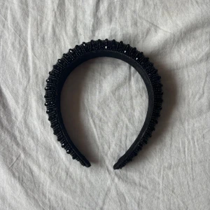 Svart diadem med pärlor - Snyggt svart diadem dekorerat med glittrande pärlor. Perfekt för att ge en elegant touch till din outfit. Diademet har en bekväm passform och är idealiskt för både vardag och fest. Stockholm stil.