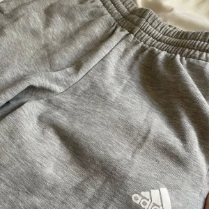 Ljus gråa sköna adidas byxor  - Säljer ett par ljusgråa sköna adidas byxor som är i storlek 11-12 men passar mig som har storlek Xs i kläder 💕💕väl använda men har fortfarande mycket att ge, finns en defekt (se sista bilden) hör av er vid fler frågor!🤗