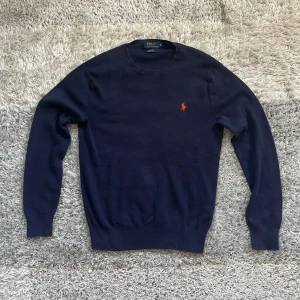 Marinblå tröja från Ralph Lauren - Hej! Säljer en stilren blå tröja från Ralph Lauren. Tröjan är i slim fit och tillverkad i pima bomull. Perfekt för en elegant och avslappnad look. Skriv gärna för fler frågor!