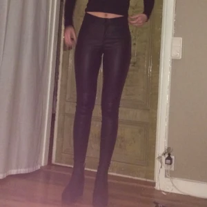 Svarta ”skinnbyxor” - Svarta byxor i typ skinnmaterial. Välanvända storlek s