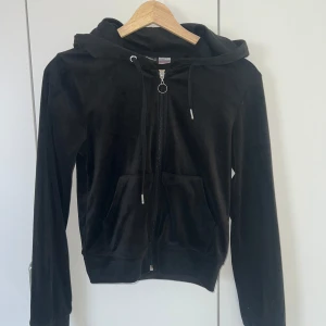 Svart croppad hoodie i velour  - Mysig och figurnära svart hoodie i mjuk velour med dragkedja framtill och huva. Tröjan har långa ärmar och två fickor framtill. Perfekt för en avslappnad stil. Aldrig använd, Inga tecken på användning. Pris kan diskuteras🥰