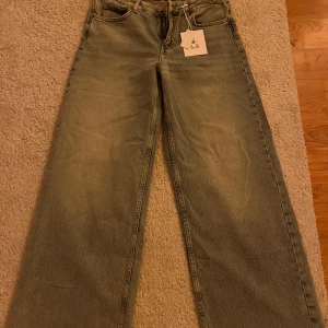 Ljusblå wide jeans  - Säljer ett par ljusblå jeans med wide leg och mid waist. Klassisk femficksmodell med dragkedja och knapp i midjan. Perfekta för dig som gillar en avslappnad stil.