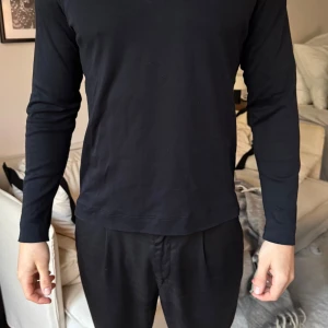 Marinblå långärmad tröja - Säljer en stilren marinblå långärmad tröja. Perfekt för en minimalistisk look och passar till många olika outfits. Tröjan har en normal passform och är tillverkad i ett mjukt material för extra komfort.