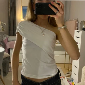 Vit one shoulder topp, helt ny - Säljer en stilren vit one shoulder topp som har prislapp kvar. 