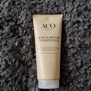 ACO Moist & Repair Conditioner - Säljer en ny oöppnad ACO Moist & Repair Conditioner som vårdar och reparerar skadat hår. Perfekt för normalt, torrt eller skadat hår och passar även känslig hårbotten. Kommer i en praktisk tub på 200 ml med snäpplock för enkel användning.