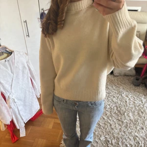 Beige stickad tröja - Mysig beige stickad tröja med ribbade muddar vid ärmslut och nederkant. Perfekt för kyligare dagar och ger en avslappnad look. Passar bra till jeans eller kjol.