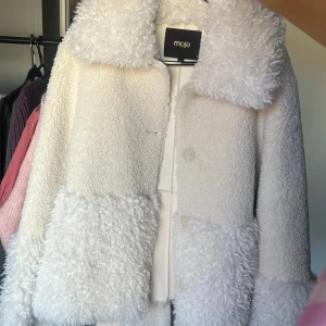 Vit teddyjacka från Maje - Säljer en supermysig vit teddyjacka från Maje. Jackan har en fluffig textur med stora knappar framtill och en bred krage. Perfekt för att hålla sig varm och stilren under kyliga dagar. 🐑✨ Orginalpris 5.500! Använd ca 2 gånger