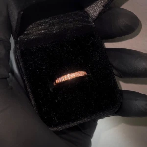 Ring Äkta 18K Gulddoublé - Ring i äkta 18K rött gulddoublé med CZ stenar. Stämplad 18K GP. Helt ny och oanvänd! Storlek innerdiameter 17.5mm. *Asken medföljer ej*